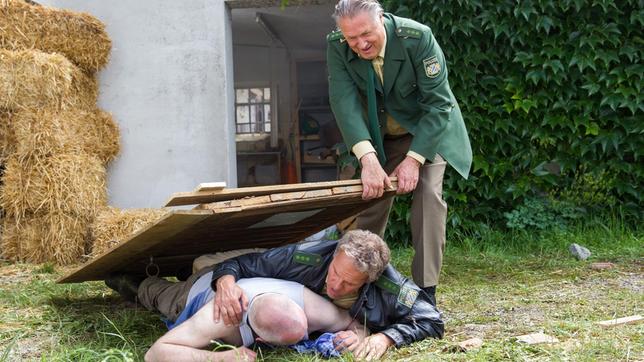 Hubert (Christian Tramitz) und Girwidz (Michael Brandner) können Herbert Moser (Rainer Haustein) gerade noch vor der Explosion retten.