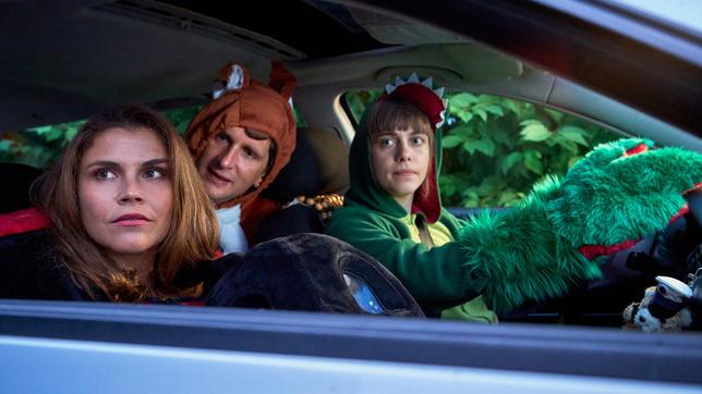Marie (Katharina Wackernagel), Heino (Sebastian Schwarz) und Jenny (Eva Bühnen) sitzen verkleidet im Auto und beobachten die ankommenden Gäste einer Kuschelparty.