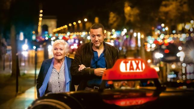 Bild: 2022 Hirondelle Productions Plakat - Die 92-jährige Madeleine Keller (Line Renaud, li.) beeindruckt den schroffen Taxifahrer Charles (Dany Boon, re.) mit ihrer Schlagfertigkeit.