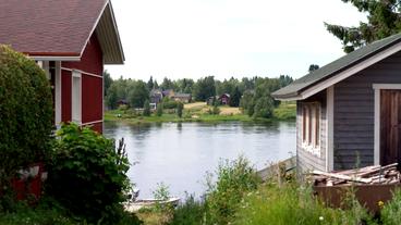 Skandinavische Holzhäuser an einem Fluss.