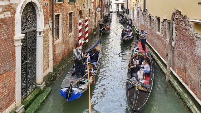 Ein kleiner Kanal in Venedig mit vielen Gondeln mit Touristen