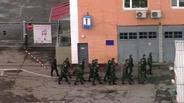 Eine Reihe Soldaten marschiert an einem Gebäude entlang