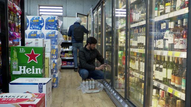 Mitarbeiter von Supermarkt räumt Regale ein 