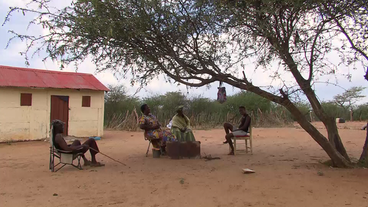 Herero sitzen vor Hütte im Freien