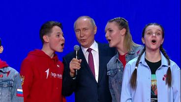 Putin mit Jugendlichen auf einer Bühne 