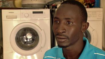 Senegal: Gefrustet nach der Rückkehr in den Senegal: Matars Geschäft mit Waschmaschinen läuft nicht