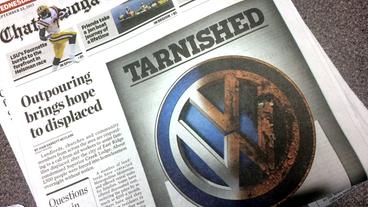 Zeitungsartikel mit einem verrußten VW-Emblem.