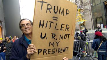 Mann mit einem Schild vor dem Trump Tower