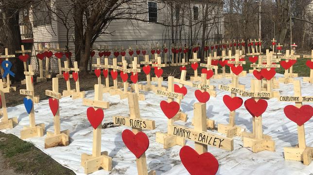 Holzkreuze mit roten Herzen und Namenstafeln