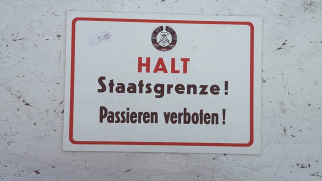 Bildquelle: Imago Schild mit DDR-Emblem und der Aufschrift "HALT Staatsgrenze! Passieren verboten!"
