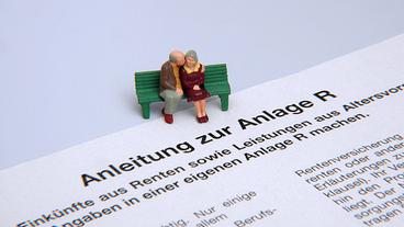 Ein Modell mit einem auf einer Bank sitzenden Rentnerpaar steht auf der Anlage für Renteneinkünfte zur Steuererklärung. 