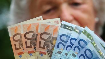 Eine Rentnerin hlt verschiedene Euroscheine in ihren Hnden. 