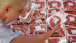 Eine Mitarbeiterin sortiert abgepacktes Fleisch in einem Khlregal.
