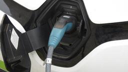 Nahaufnahme einer Auto-Steckdose, an der ein Ladekabel hngt.