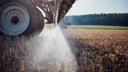 Ein Traktor bringt auf einem Feld Glyphosat aus.