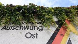 Auf einer Mauer ist der verwitterte Schriftzug Aufschwung Ost zu lesen