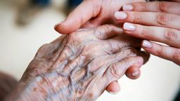 Die Hand einer alten Frau liegt in der einer jungen