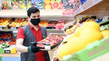 Mitarbeiter im Supermarkt fllt Ware auf