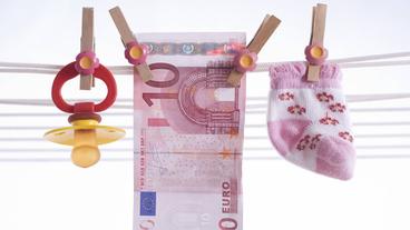 Bild: Imago Ein Zehn-Euro-Schein hängt an einer Wäscheleine zwischen einem Babysöckchen und einem Nuckel.