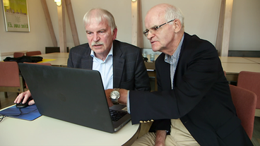 Die Finanzexperten Werner und Günter Siepe sitzen vor einem Laptop.