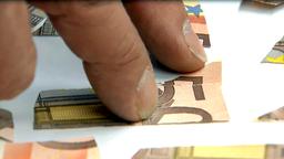 Einzelne Teile eines 50-Euro-Scheins liegen auf einem Tisch