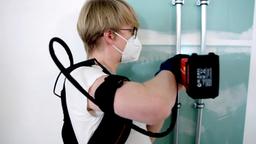 Handwerker entlastet Rcken mit Exoskelett
