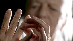 ltere Dame betrachtet ihre Fingergelenke