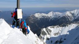 Zwei Personen an einer Mess-Station in den Alpen.