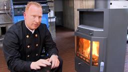Schonsteinfeger neben einem Kaminofen