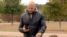 Mann mit Rad, schaut auf sein Handy.