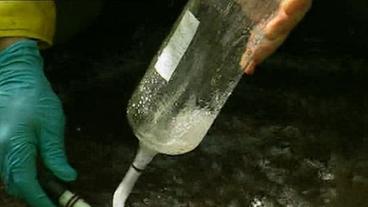 Sprudelndes Wassr wird in Glasbehältnis gefüllt