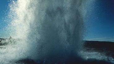 Eine Wasserfontäne eines Geysirs, der sich bei Strokkur auf Island befindet, spritzt in die Höhe