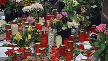 Niedergelegte Kränze, Blumen und Kerzen als Zeichen der Trauer