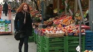 Frau geht am Gemüse-Stand vorbei