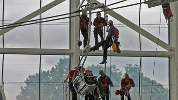 bergwachtler üben die Rettung aus einem Sessellift in einer Halle