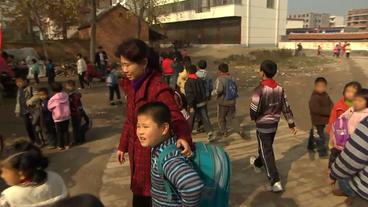 Eine Mutter holt ihren Sohn von der Schule ab