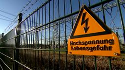 Zaun mit einem Schild "Hochspannung Lebensgefahr"