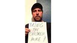 Bjarne Mädel mit einem Schild mit der Aufschrift: Bring the children home