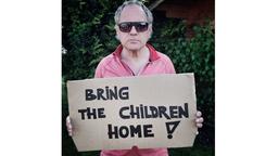 Uwe Ochsenknecht hält ein Schild hoch mit der Aufschrift: Bring the children home 