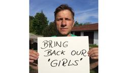 Richie Müller zeigt ein Schild mit der Aufschrift: Bring Back Our Girls 