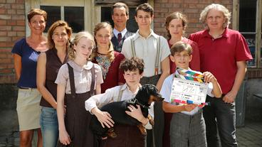 Bild: ARD Degeto/WDR/Ester Reglin Film/Dor Film/Anjeza Cikopano Von links nach rechts: Isabelle Welter (Dor Film), Roswitha Ester (Ester.Reglin.Film), Charlotte Lorenzen (die junge Trude Löhr) daneben Saskia Sophie Rosendahl (die ältere Trude Löhr), Florian David Fitz (Mitte hinten), Jascha Baum (der ältere Hans Löhr), Katharina Lorenz (Lotte Löhr), Wolfang Murnberger (Regie) und vorne Nico Ramon Kleemann (der junge Hans Löhr) mit Dackel Piefke und Juls Luis Seger (der junge Wolfi Stern, Hans‘ bester Freund).