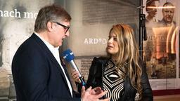 Premierenfeier von "Die Himmelsleiter – Sehnsucht nach morgen": Carlo Rola beim WDR-Interview.