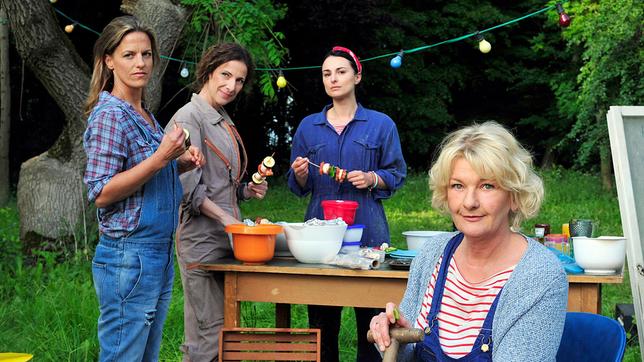 Die Freundinnen Eva (Saskia Vester, vorne), Kiki (Mimi Fiedler, 2. v. re.) und Judith (Clelia Sarto, 2. v. li. ) beobachten amüsiert das Treiben von Estelle und Steiner. Einzig Caroline (Janna Striebeck, li.) ist etwas misstrauisch.