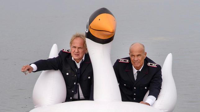 Bild: ARD Degeto/André Poling Heinrich (Heiner Lauterbach) und Tom (Uwe Ochsenknecht, li.) bei der Seebestattung.