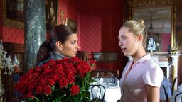 Lea (Sandra Speichert, li.) hat von ihrem Verflossenen einen Strauß Rosen geschickt bekommen und bittet Zimmermädchen Lucy (Marisa Leonie Bach), sie als Tischdekoration zu verwenden.