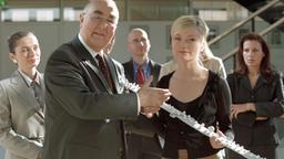 Voller Vorfreude präsentieren Ministerialdirigent Grabow (Ludwig Haas) und Justitiarin Lena Seidel (Johanna Christine Gehlen) das Modell der geplanten Autobahntrasse.