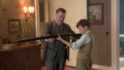 Wolter (Peter Kurth) erklärt Helgas Sohn Moritz (Ivo Pietzcker) das Gewehr.