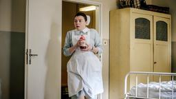 Lernschwester Petra (Amber Marie Bongard) eilt mit einer Blutkonserve ins Krankenzimmer von Bergmann Walter Neumann.