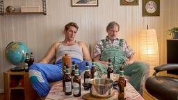 Heino (Sebastian Schwarz) und Paul (Michael Wittenborn) sitzen zusammen betrunken auf dem Sofa und schauen Fernsehen.