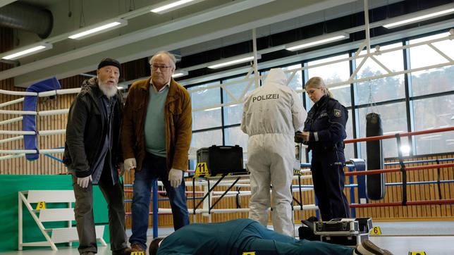 Bielefelder (Bill Mockridge) und Klaus Schmitz (Hartmut Volle) begutachten den Tatort. Handballtrainer Rainer Teichmann ist kaltblütig ermordet worden (mit Komparserie).